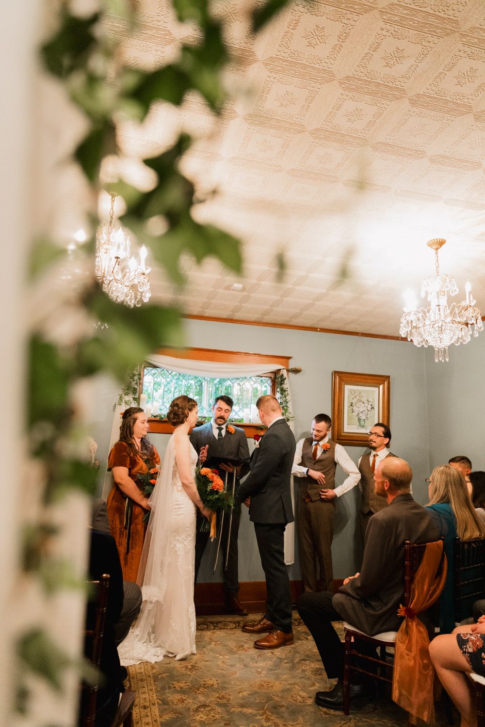 Wedding guests enjoy dancing and celebrating together in an elegant ballroom with crystal chandeliers and floral decor.