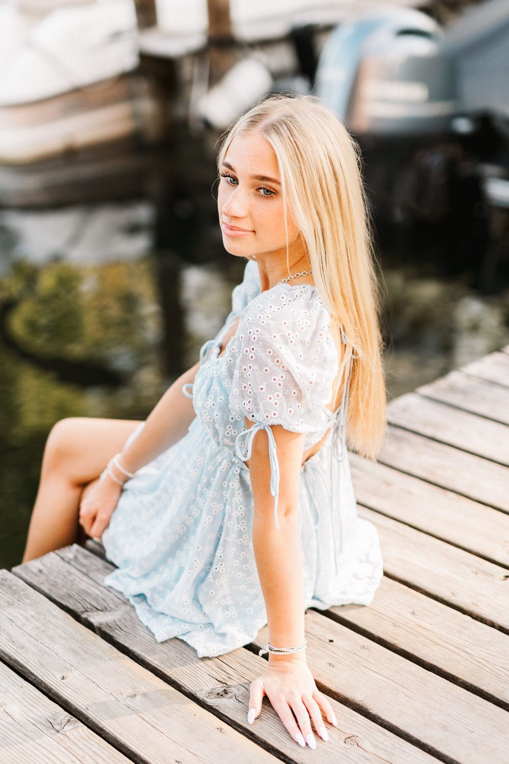 Lifestyle portraits captured on a wooden pier with soft natural lighting and water reflections.