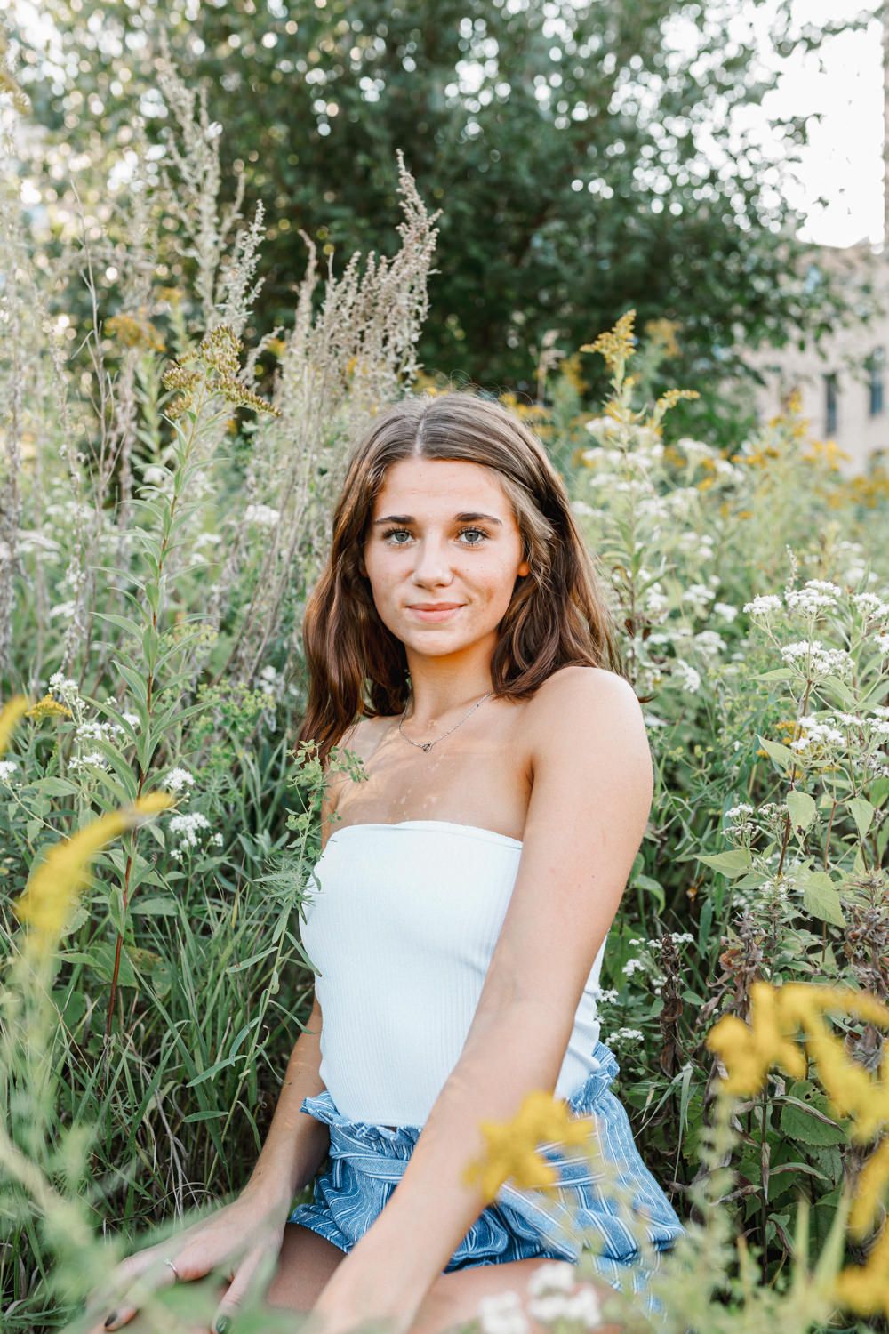 Summer garden portrait with white top among wildflowers.
