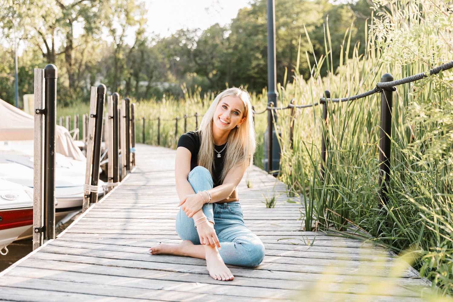 Casual outdoor photography session on wooden walkway surrounded by natural grasses.