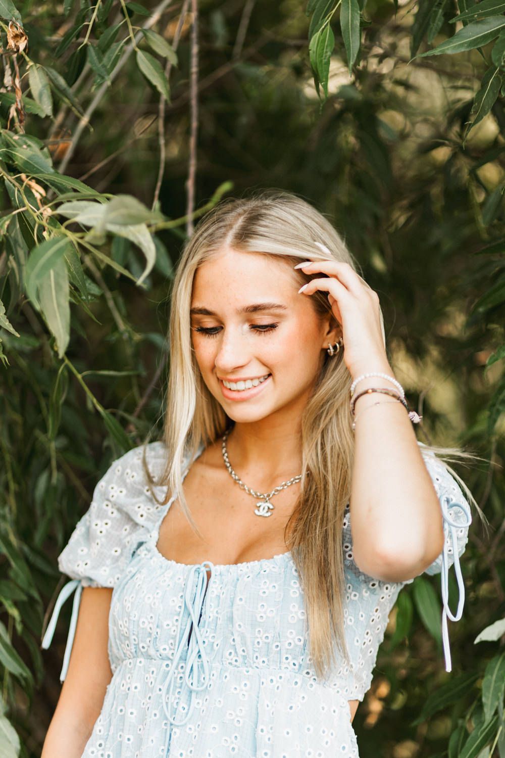 Candid moment captured in light summer dress with hand in blonde hair.