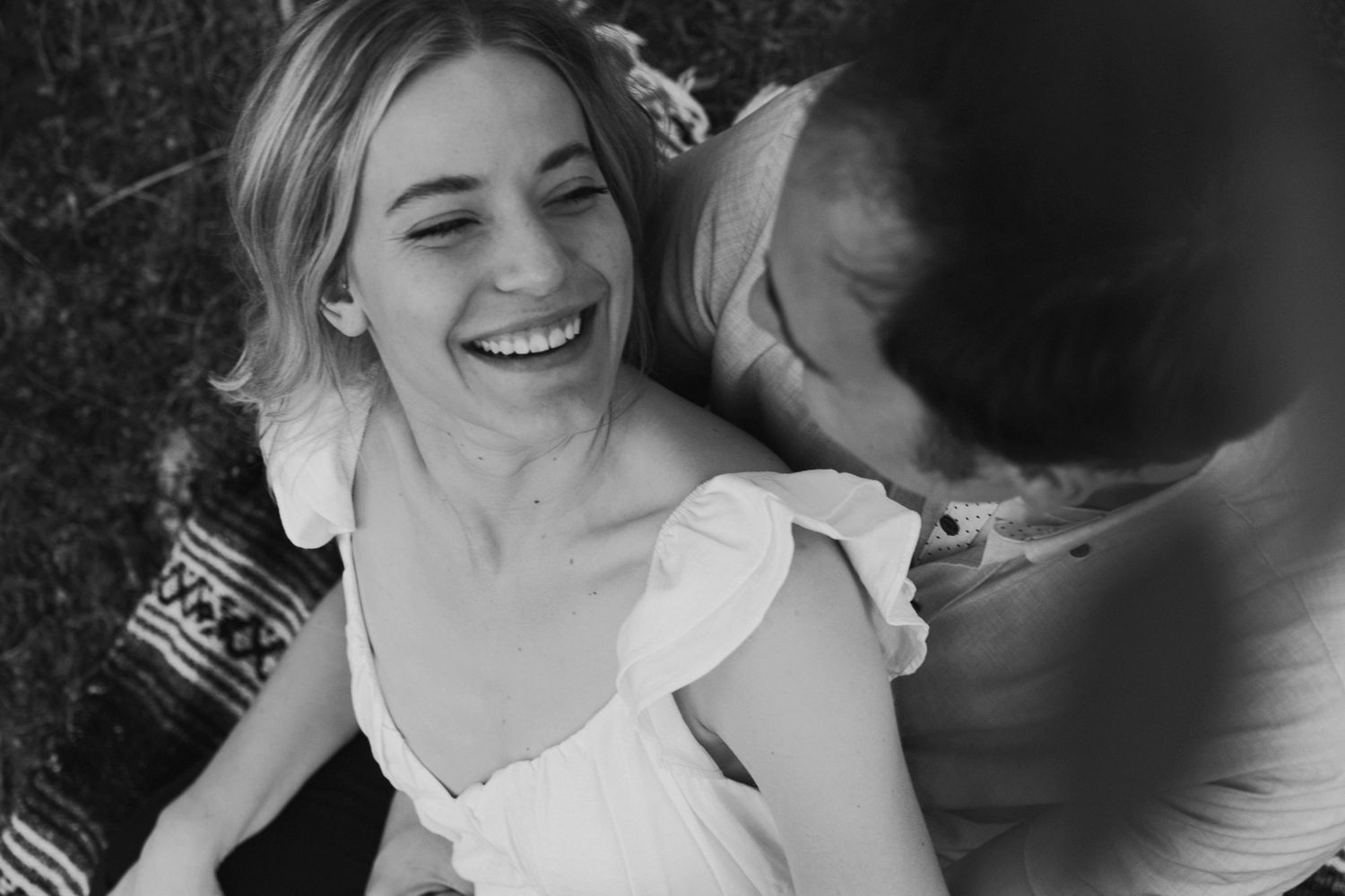 Black and white portrait capturing genuine laughter and intimate moment.