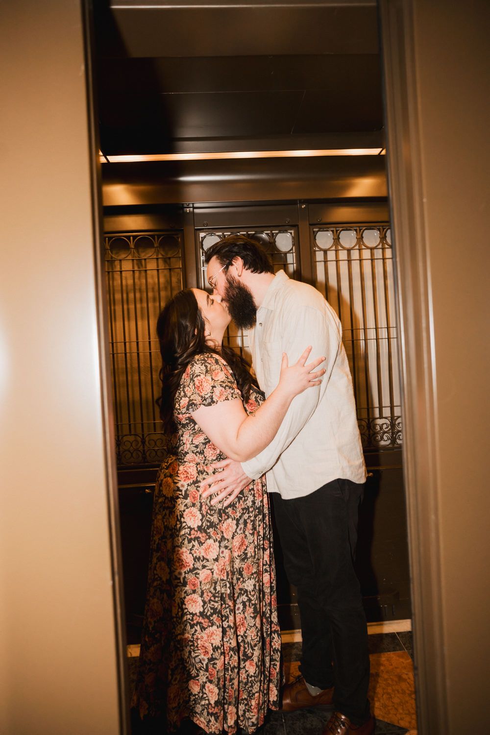 Couple dancing and embracing in a warmly lit indoor space with vintage decor.