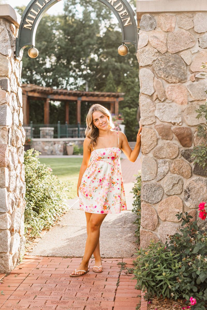 Outdoor garden session featuring stone archway and brick pathways surrounded by flowering plants.
