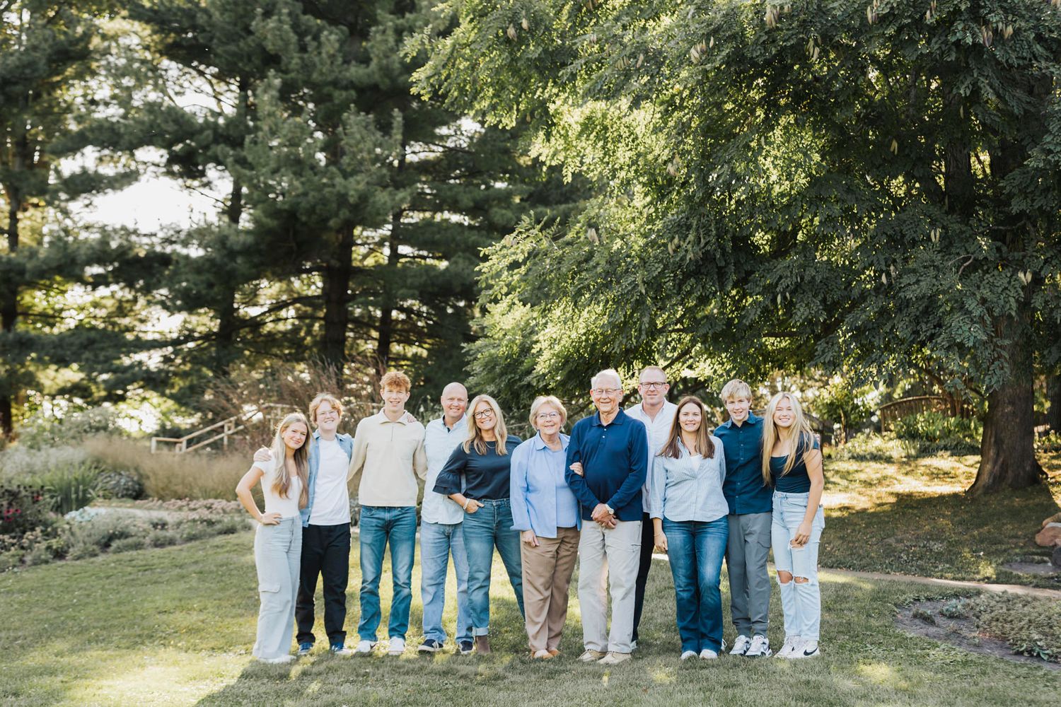 A coordinated group photo of people wearing blue and white outfits standing together outdoors in a park setting.