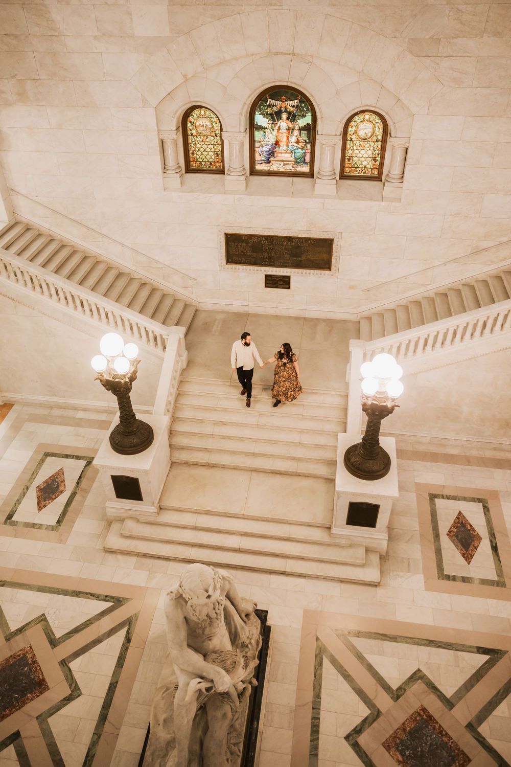 Aerial view of a grand marble staircase with geometric patterns and ornate architectural details.