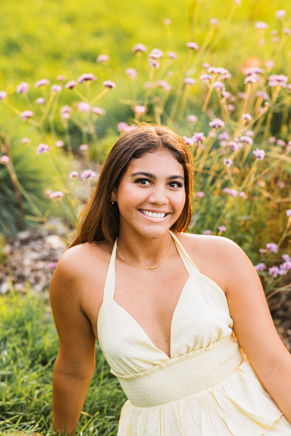 A series of sunny outdoor portraits showing someone in a cream-colored dress sitting among blooming wildflowers.