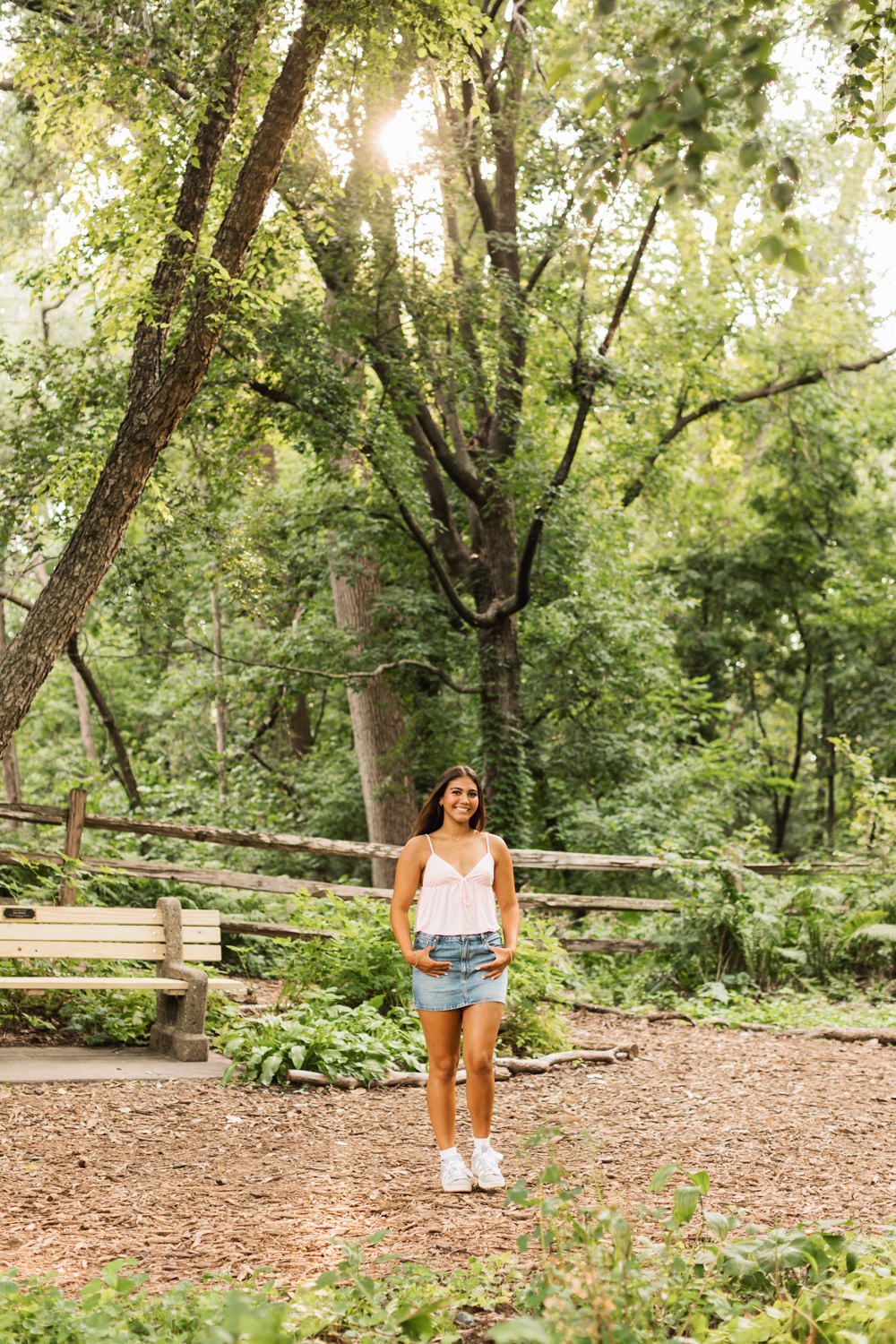 Summer portrait session in a wooded park with natural sunlight filtering through trees.