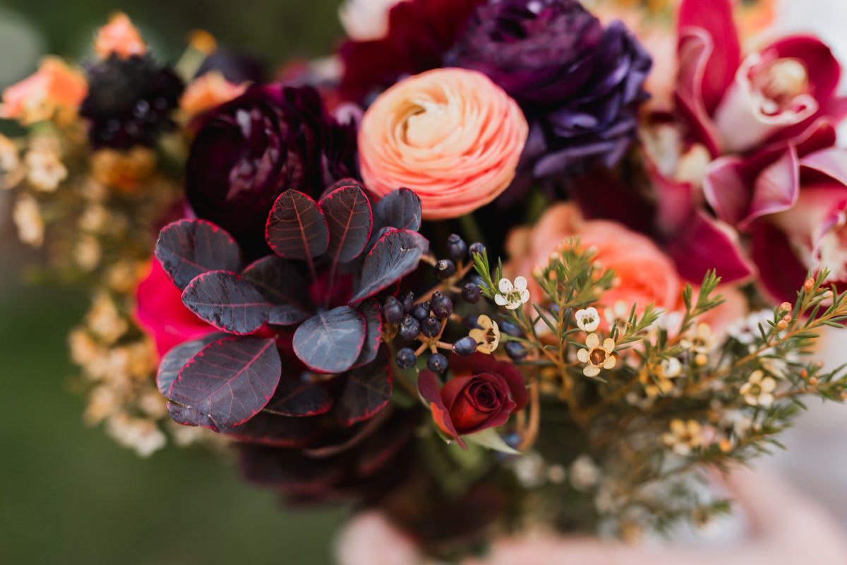 Close-up of a stunning wedding bouquet featuring deep purple and pink flowers with delicate details.