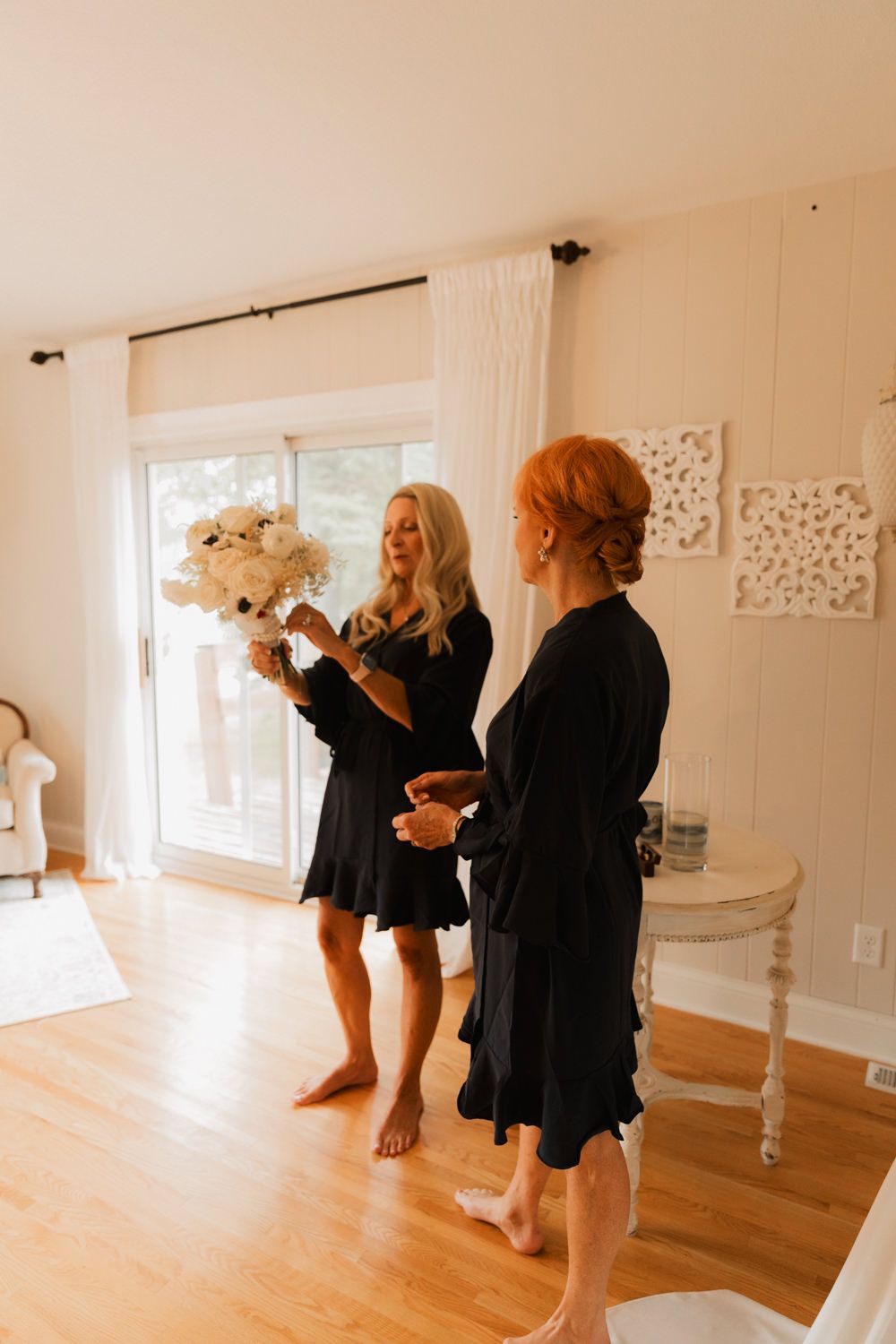 A series of candid photos showing people in black dresses interacting in a bright white studio space.
