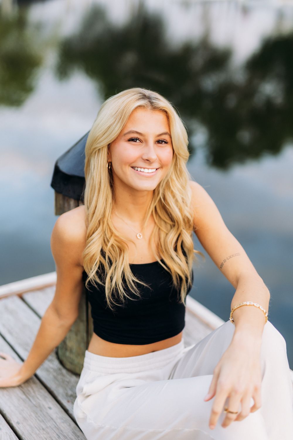 Cropped portrait photos of a person with blonde hair smiling and posing outdoors near water in athletic wear.
