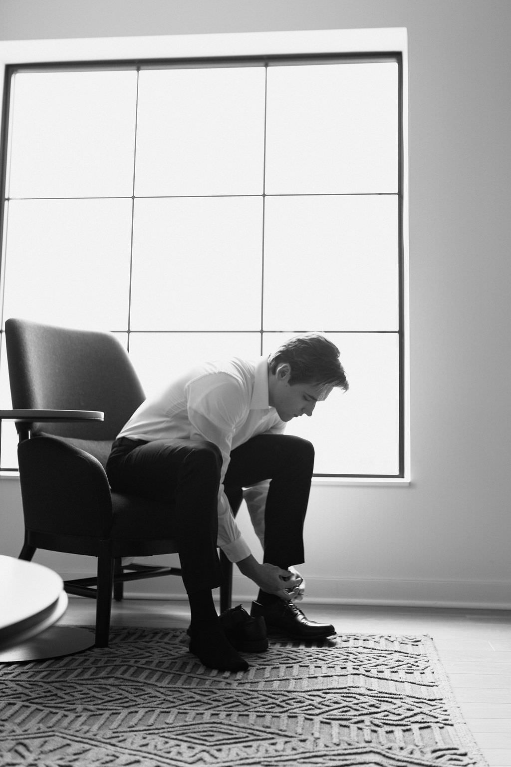 A sequence of black and white photos showing a figure sprawled across the floor in an empty modern room.