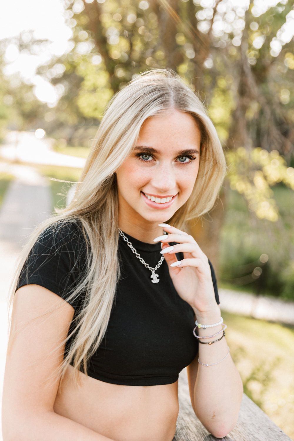 Close-up portrait series showing casual black top and silver necklace styling.