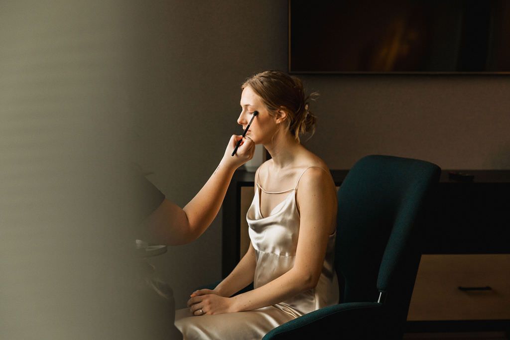 Moody bridal getting ready photos in dramatic window light.