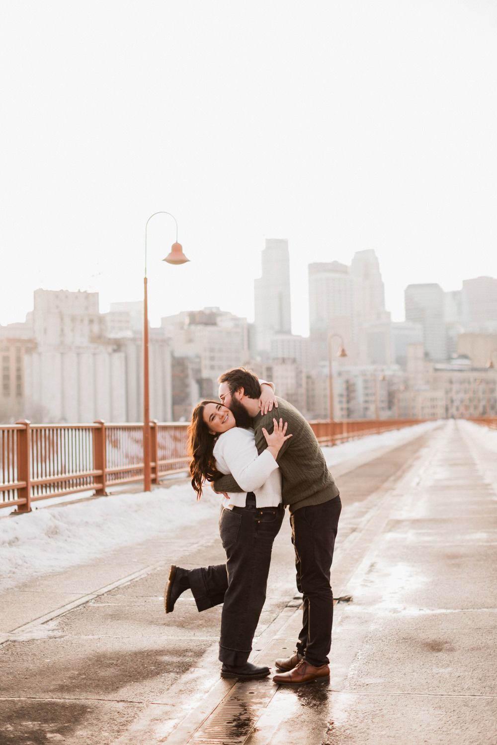 Romantic proposal sequence on a bridge with city skyline backdrop.