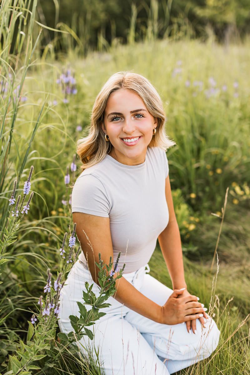 A summer portrait session in a wildflower meadow featuring a casual white and grey outfit.