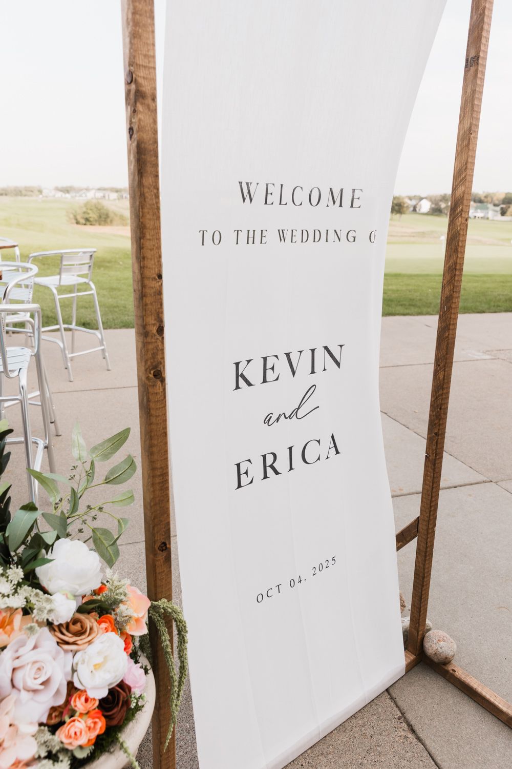Modern white wedding welcome signs with floral decorations display 'Kevin and Erica' text.