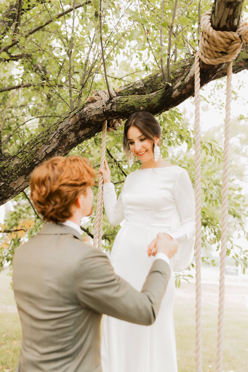 A romantic first look moment captured between a couple in a dreamy outdoor garden setting with soft natural lighting.