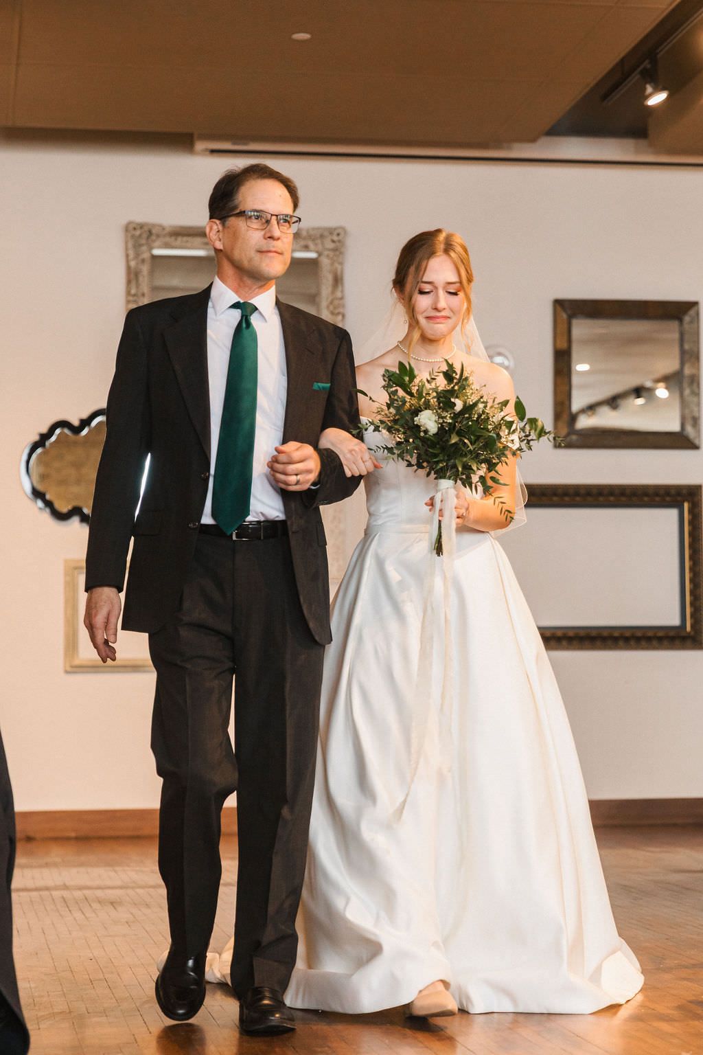 Warm-toned wedding photos showing a couple dancing together in an elegant indoor venue.
