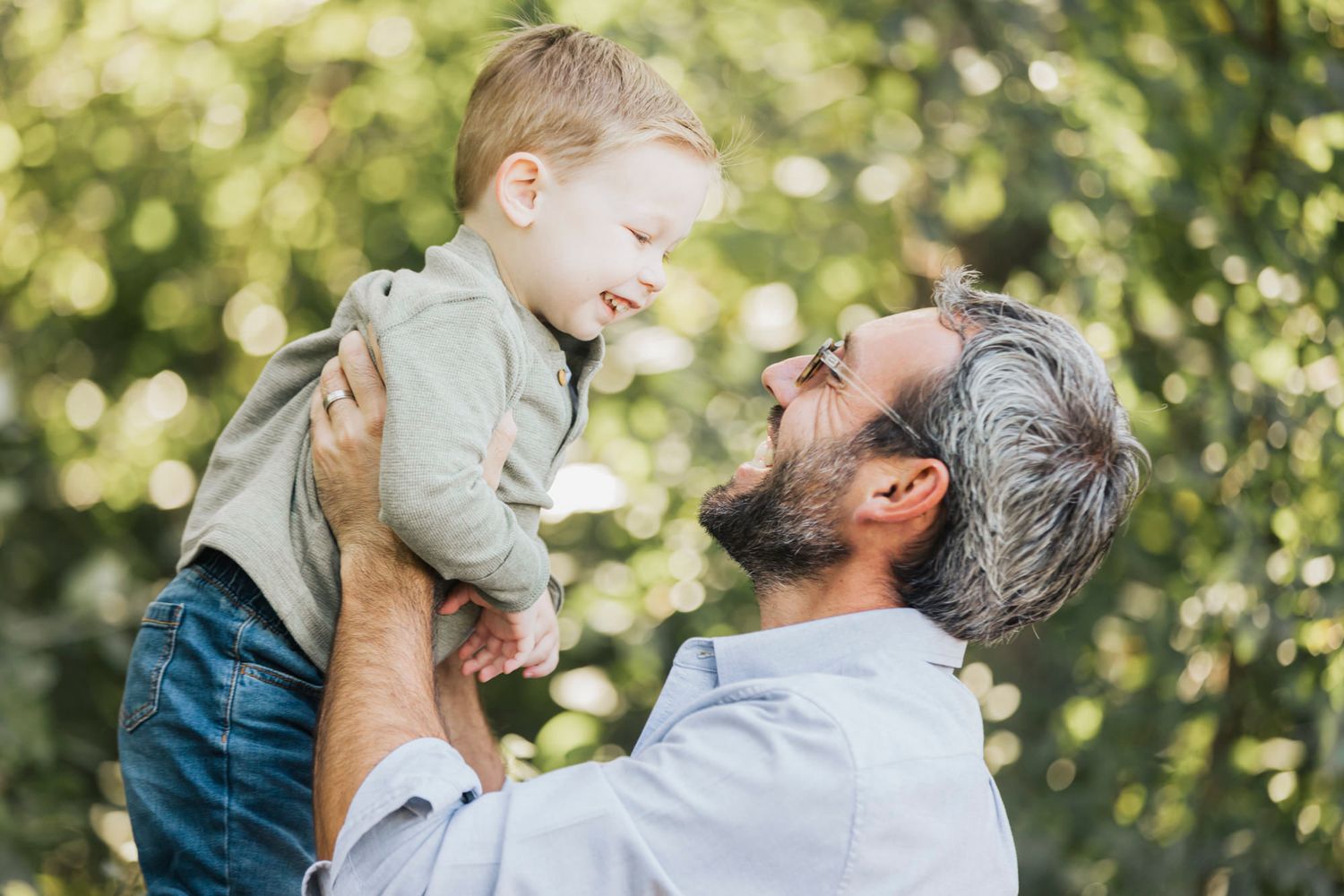 Candid moments of joy and laughter captured between parent and child in outdoor setting.