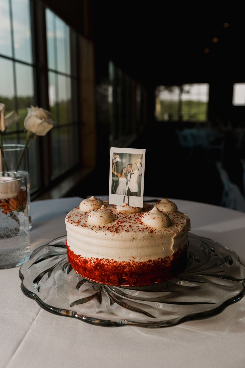 Four sequential shots of a red velvet cake with white frosting displayed on an elegant glass serving plate.