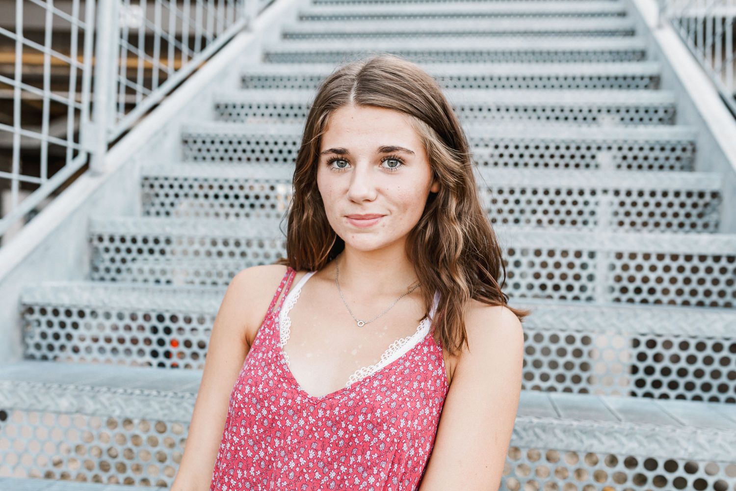 Modern portrait on industrial metal stairs with bright natural lighting.