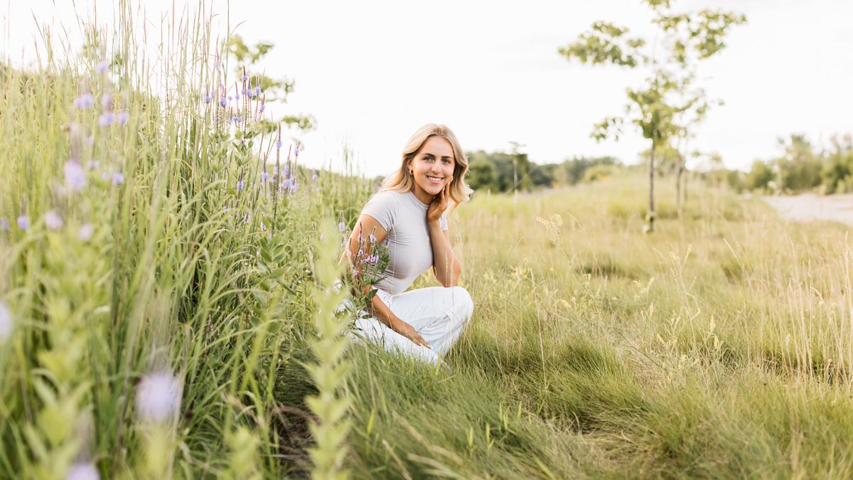 Wedding photographer captures candid moments in golden fields during a romantic sunset photoshoot.