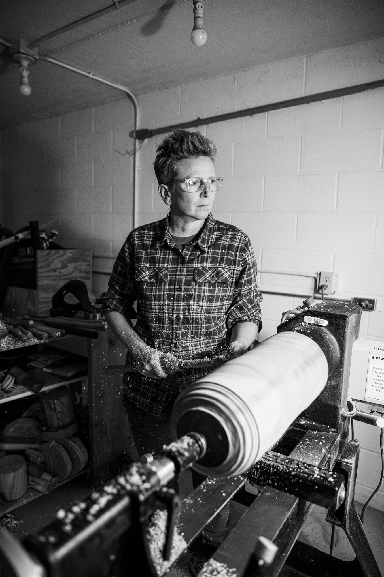 Black and white photo of craftsperson working with industrial printing equipment.