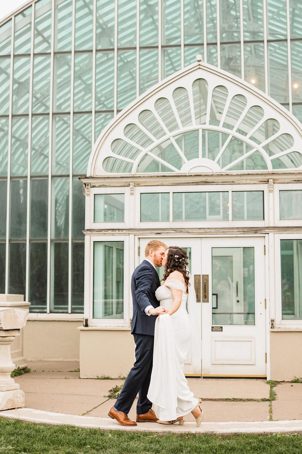 Romantic wedding portraits taken against the backdrop of an elegant glass conservatory.