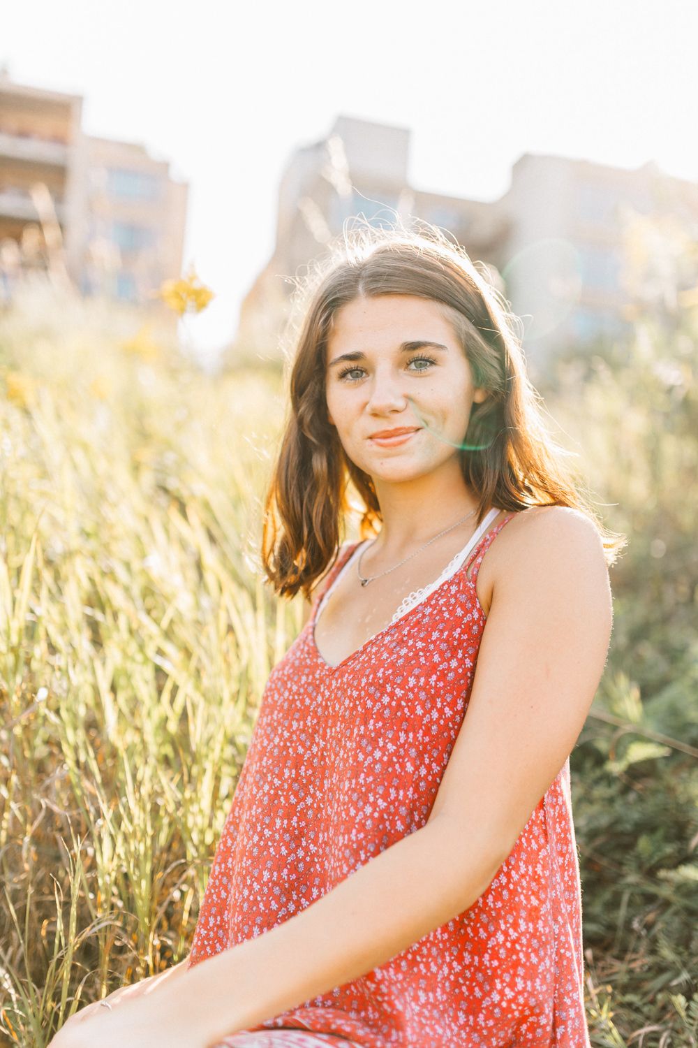 Golden hour portrait session featuring a red spotted dress against urban backdrop.
