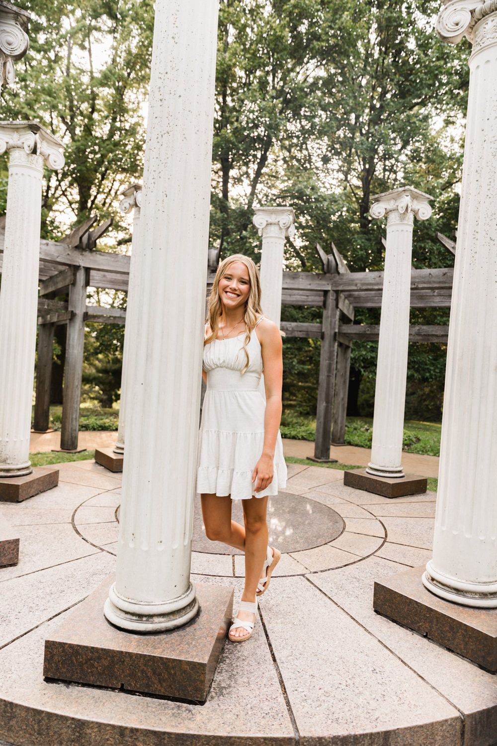Series of photos showing someone posing in a white dress under a columned pergola with brick paving.