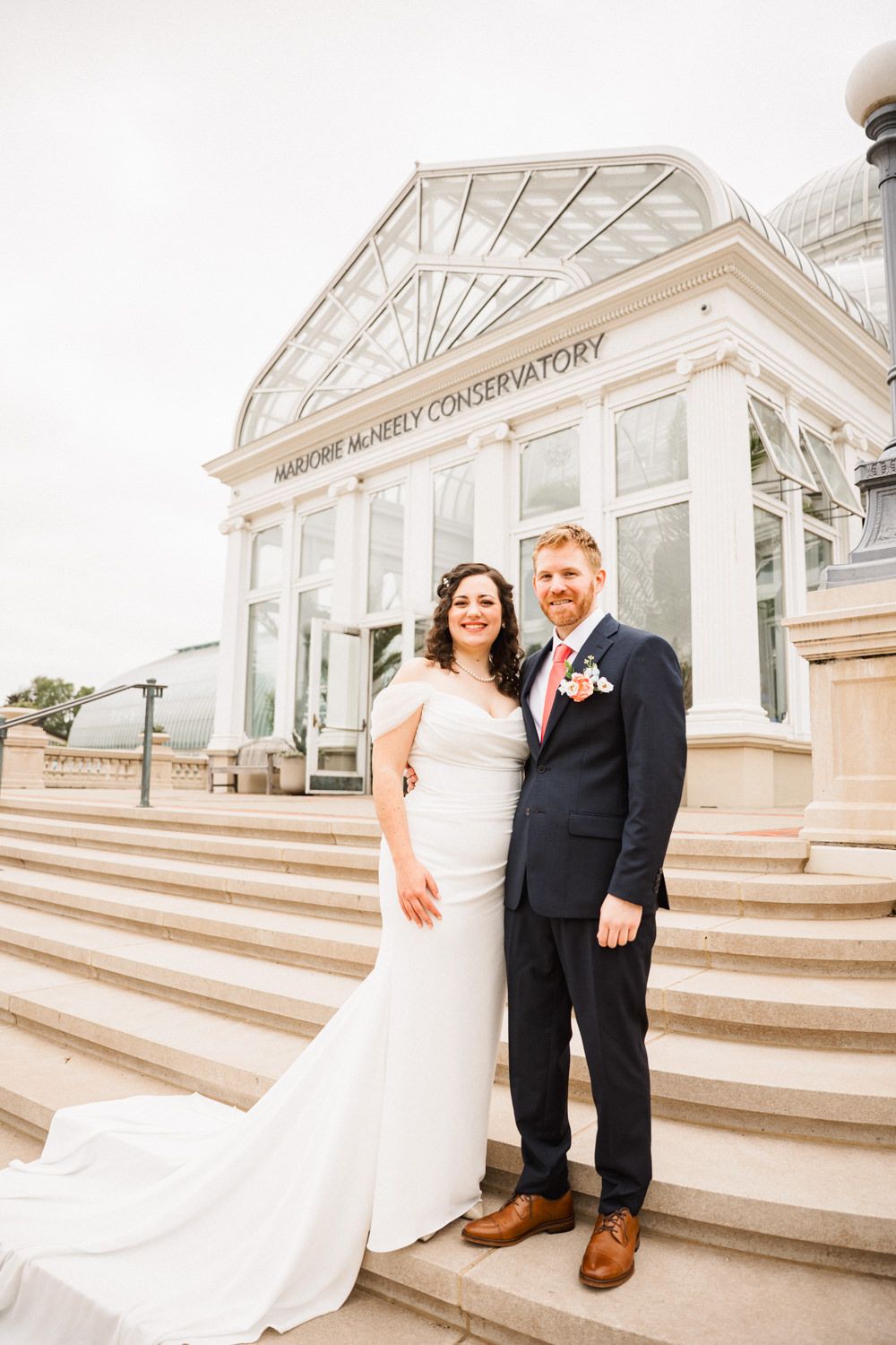 Wedding couple poses on the steps of Marjorie McNeely Conservatory.