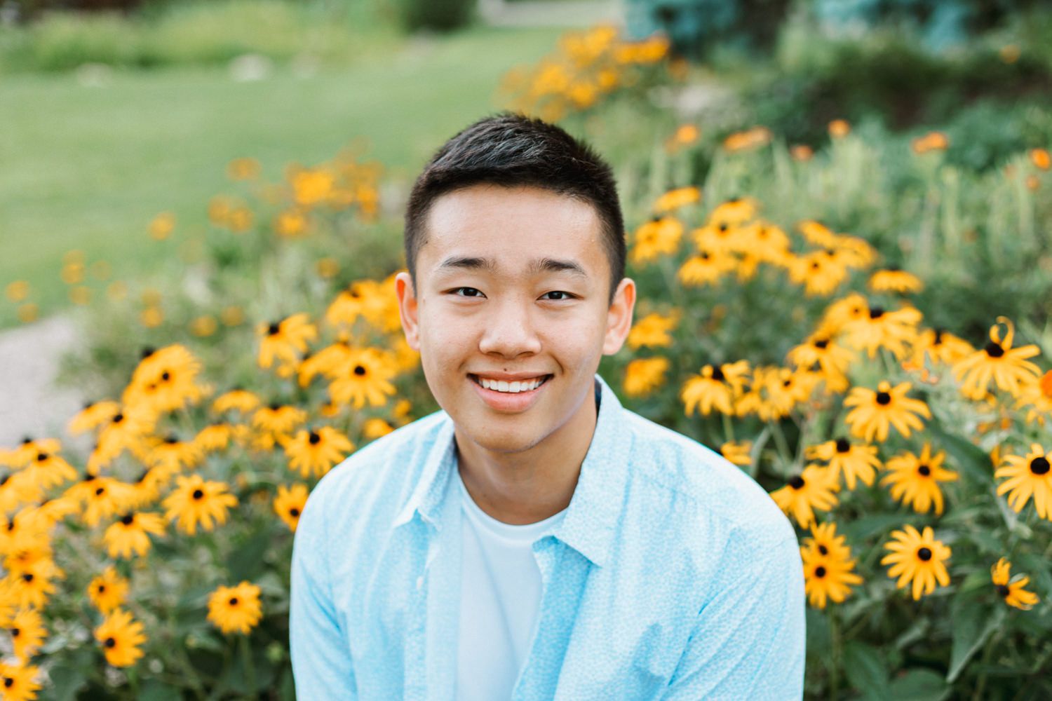 Garden portrait with vibrant yellow flowers and natural greenery in background.