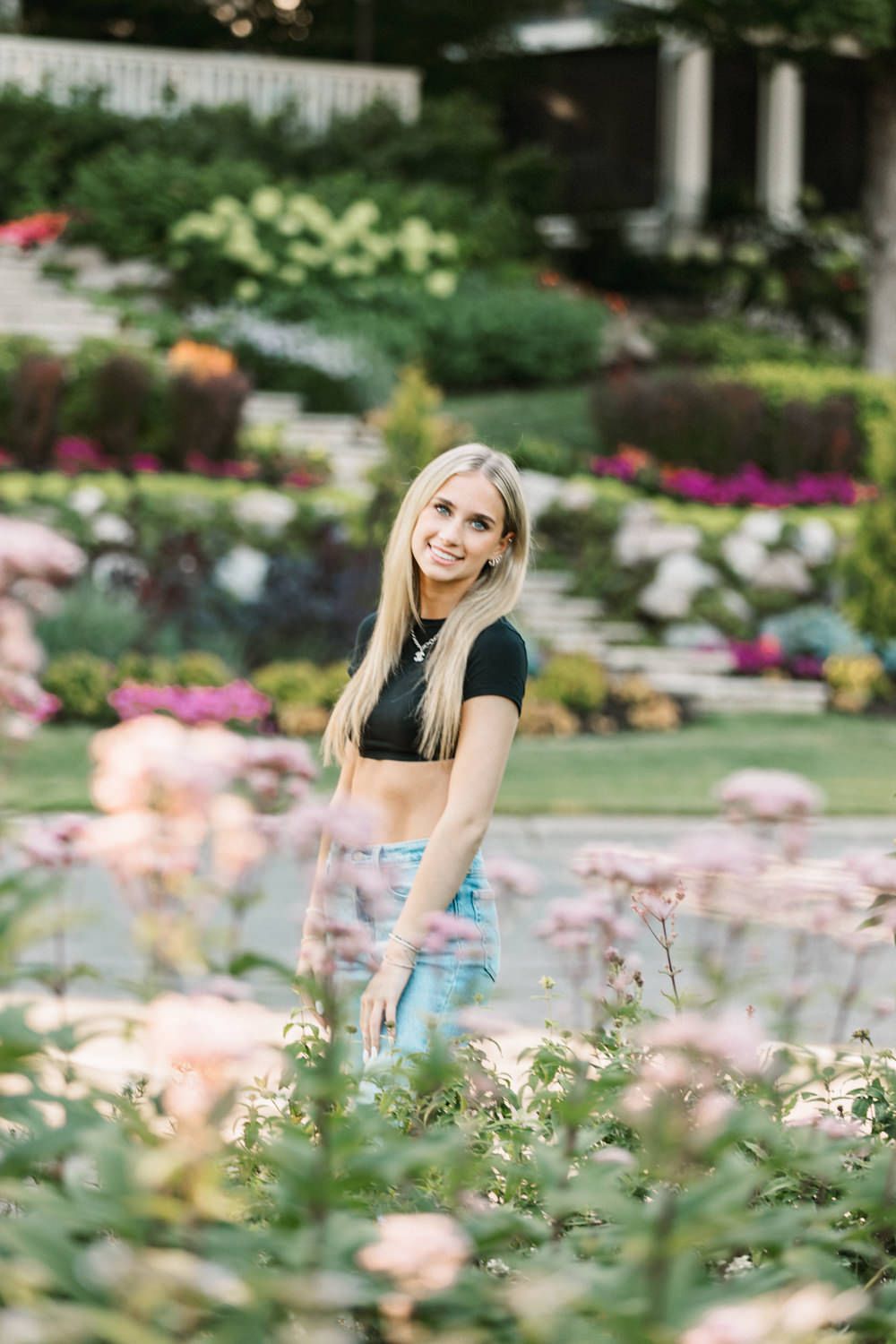 Outdoor portraits with vibrant flower garden and colorful blooms in foreground.