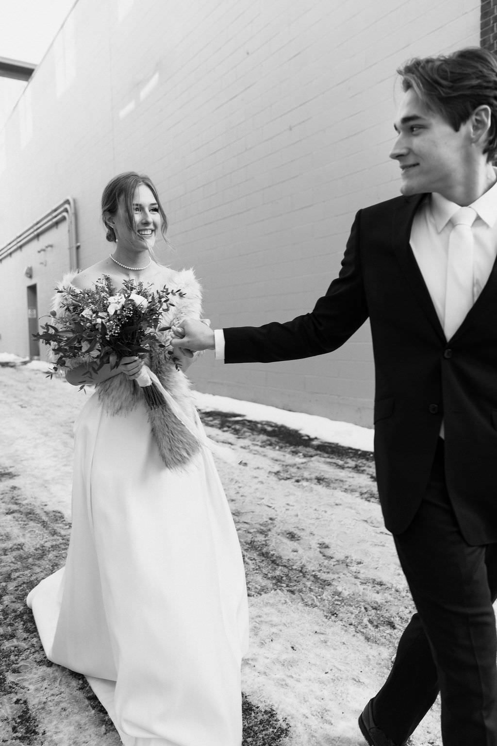Black and white wedding photos showing romantic moments between couples against white wall backdrop.