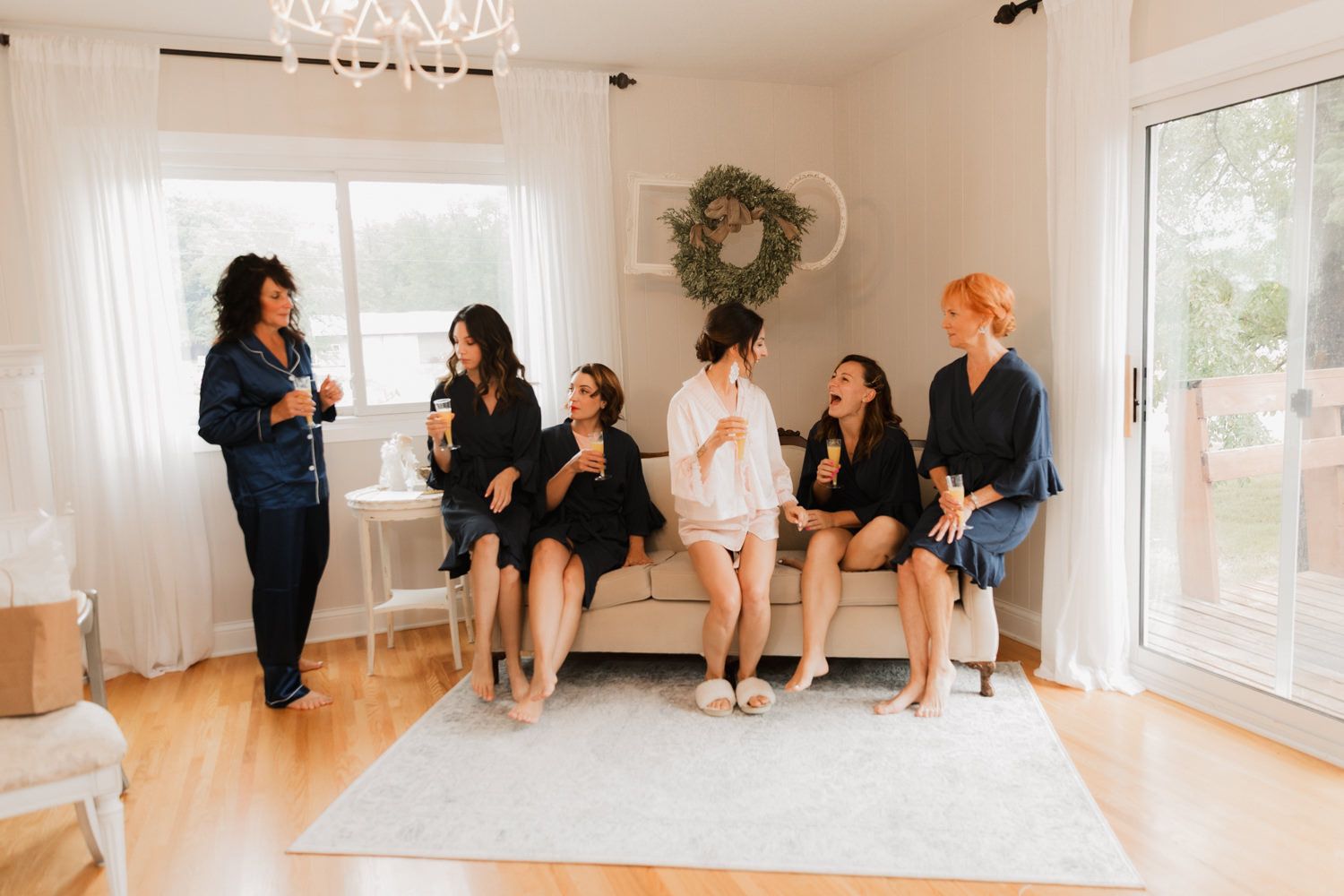Light-filled studio space with people sitting along the wall during a gathering.
