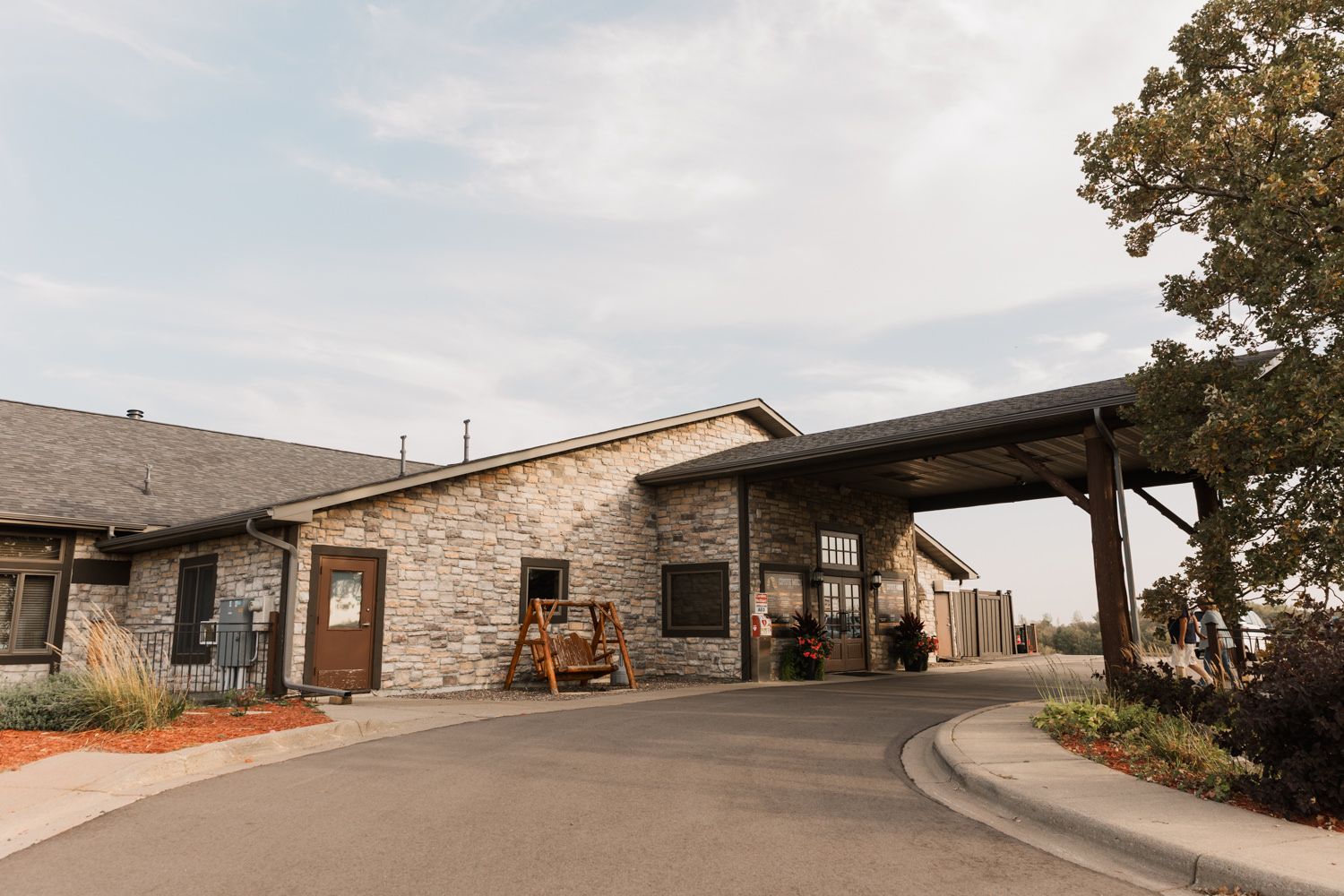 Stone and brick wedding venue exterior with scenic hillside views and covered patio areas.