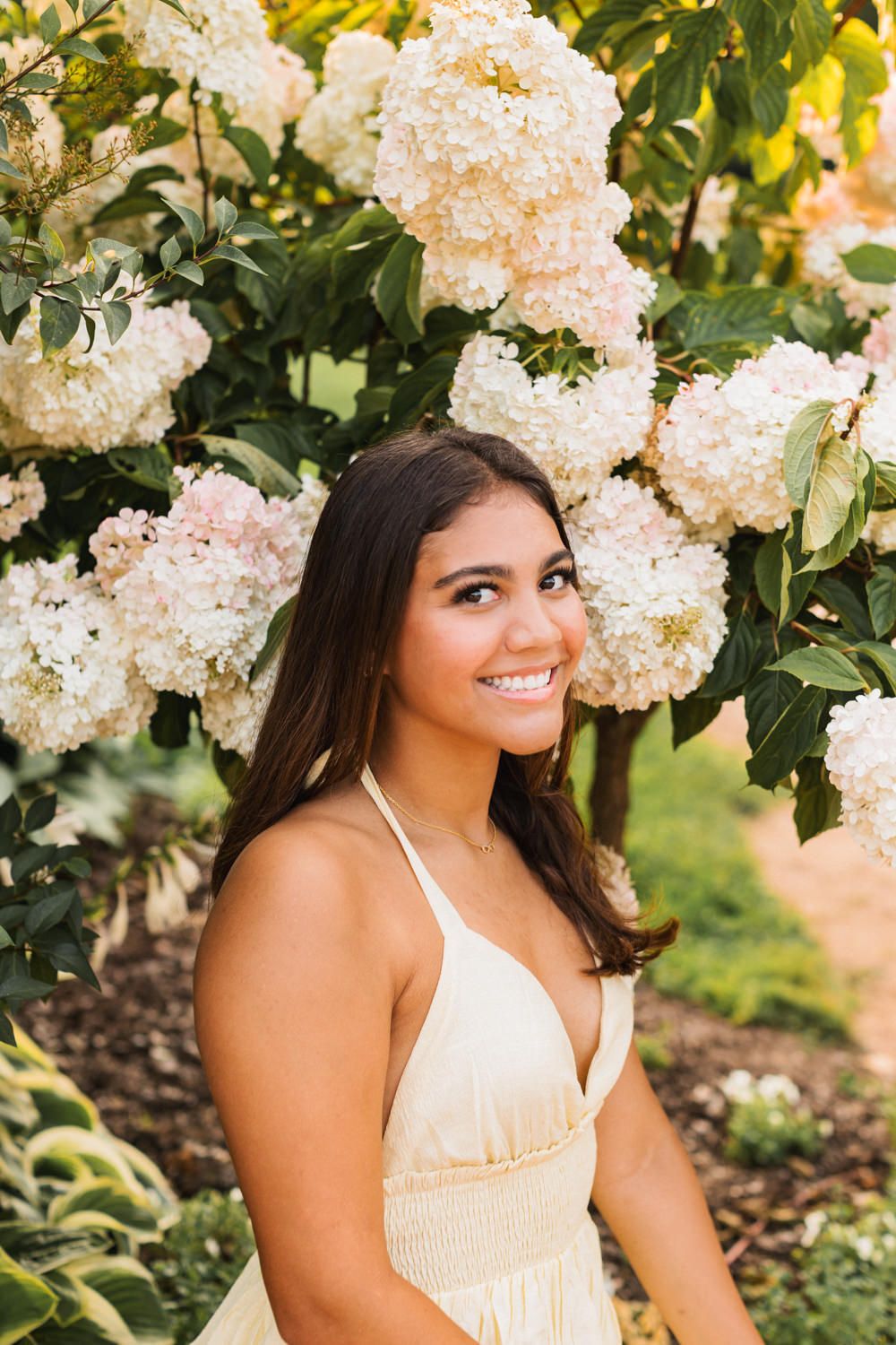Creamy white floral blooms surround a summer portrait scene with natural lighting and greenery.
