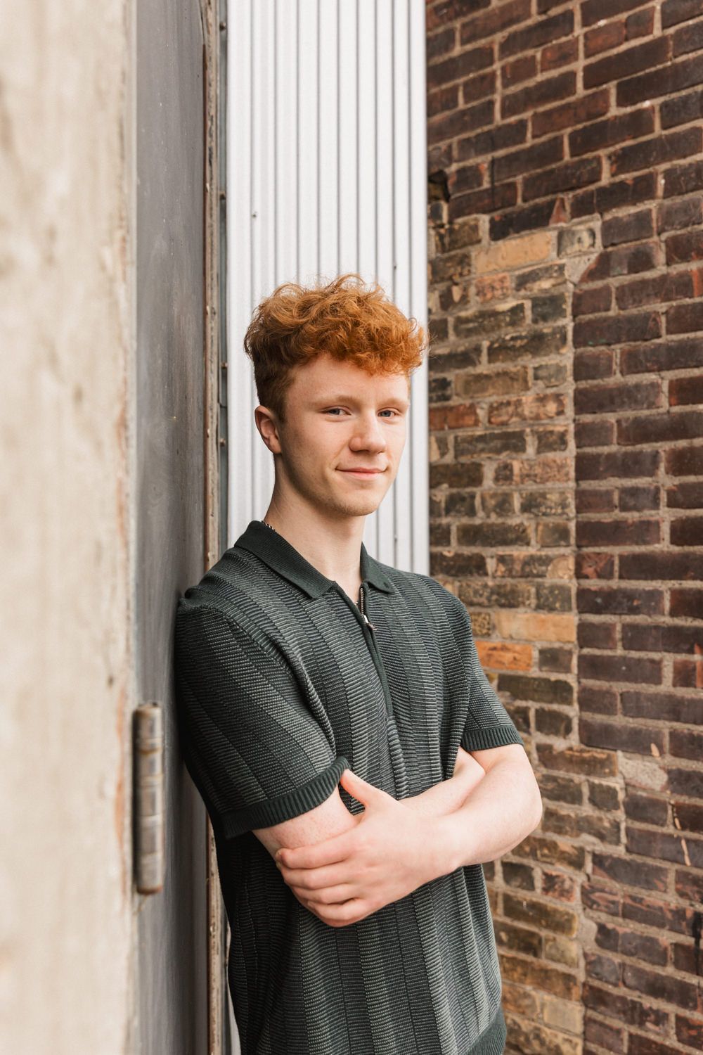 Portrait poses against a brick wall with white trim showing casual style.
