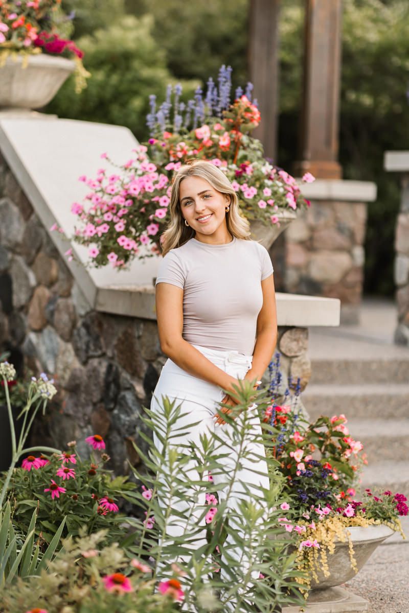 Colorful flower garden scene with blooming pink and red flowers framing a summer portrait.