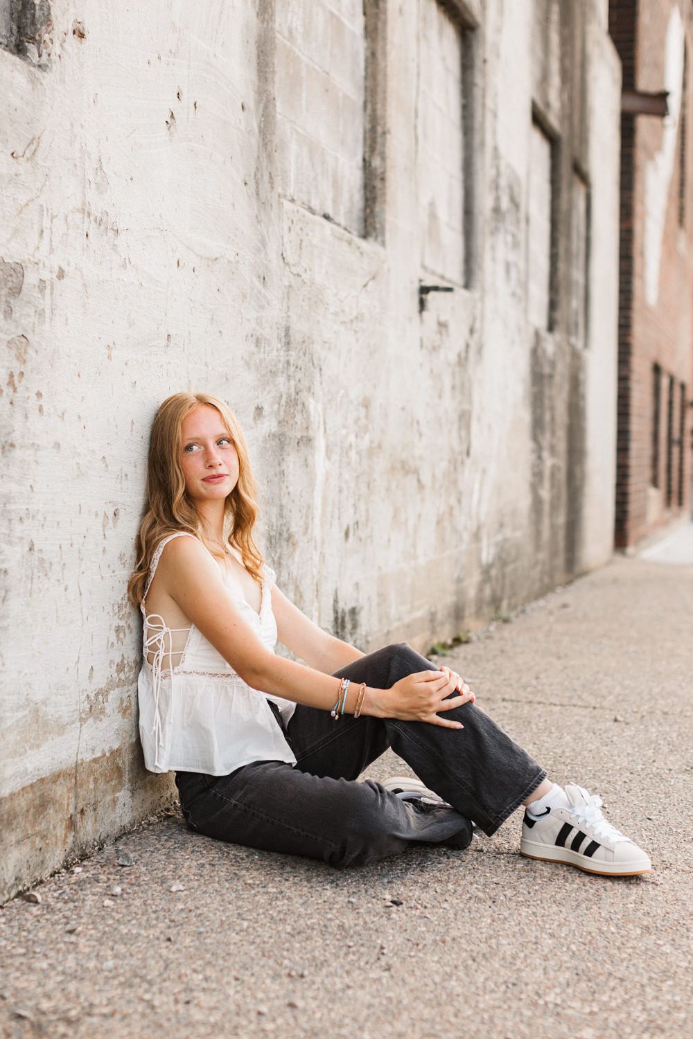 A casual photo shoot along a concrete wall with sneakers and relaxed poses.
