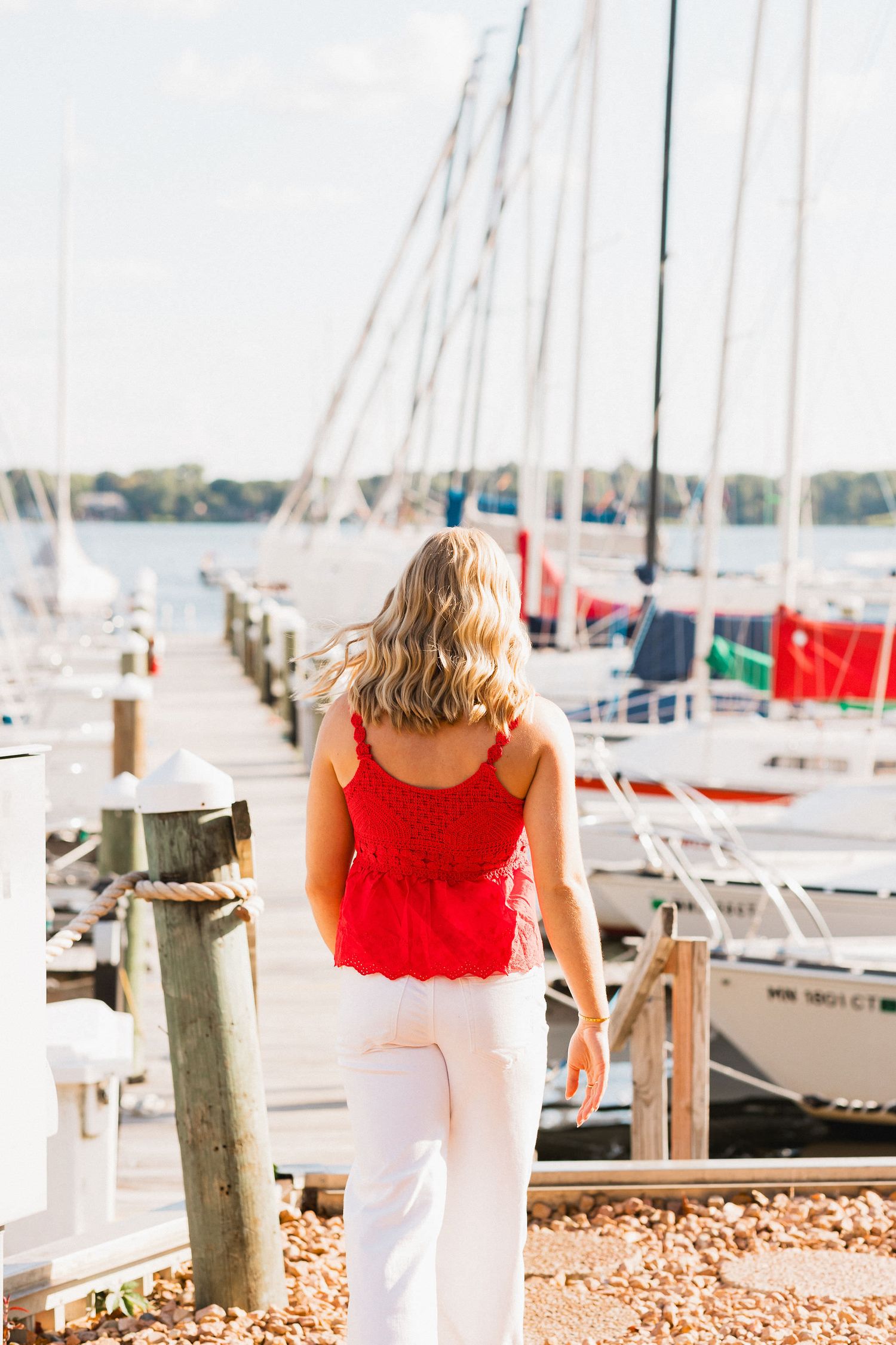 Nautical scene at a marina with sailboats and docks in the background.