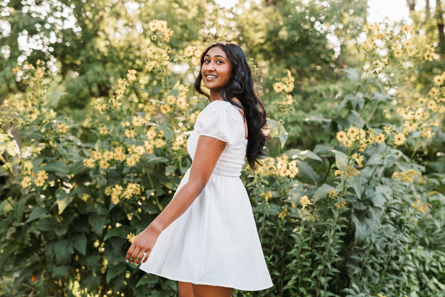 White summer dress twirling against a lush garden backdrop with golden sunlight.