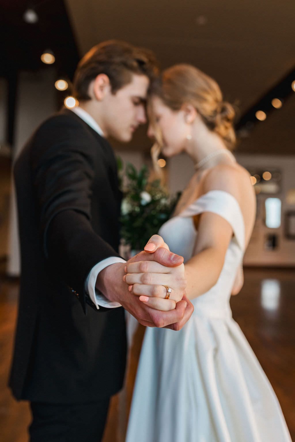 Close-up shots of a couple dancing at their wedding reception showing intimate hand-holding moments.