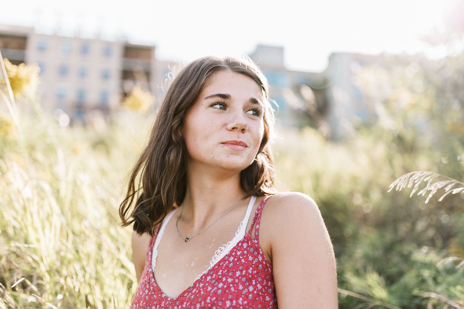 Lifestyle portrait session in a red dress during magic hour lighting.