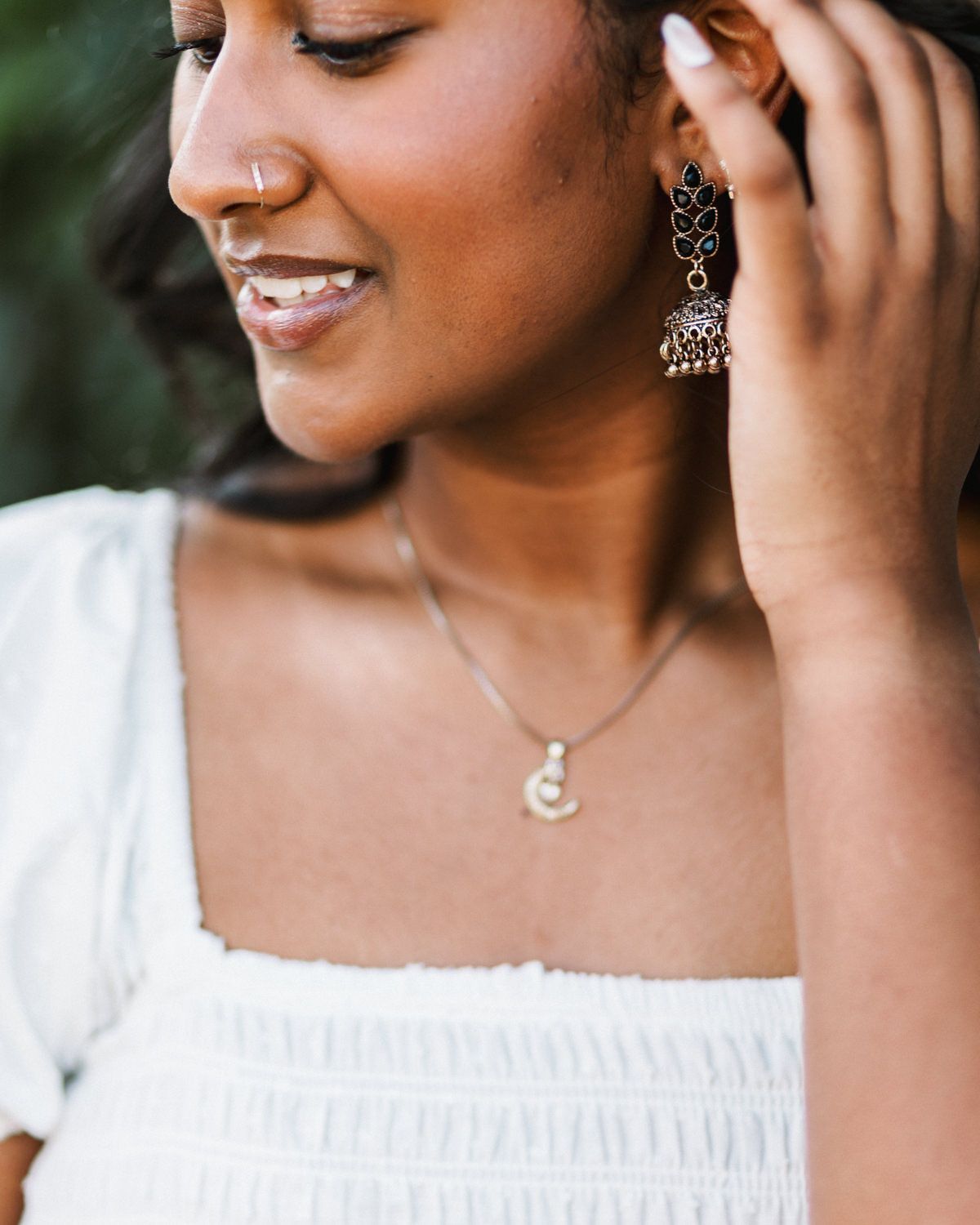 Close-up portrait series showing delicate jewelry and white clothing details.