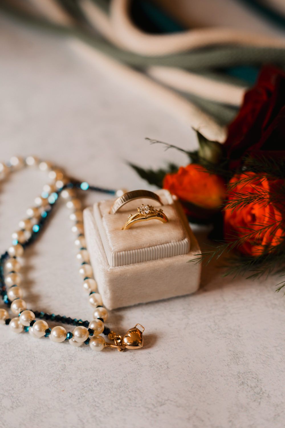 A delicate pearl bracelet with gold accents lies elegantly arranged on a light textured surface.