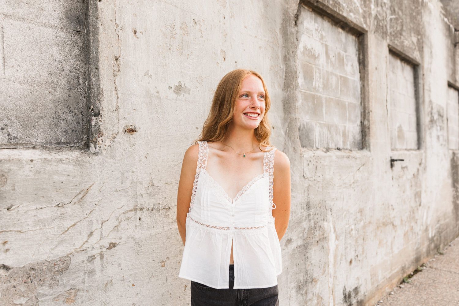 A lifestyle photoshoot session featuring white tank top and neutral backdrop.