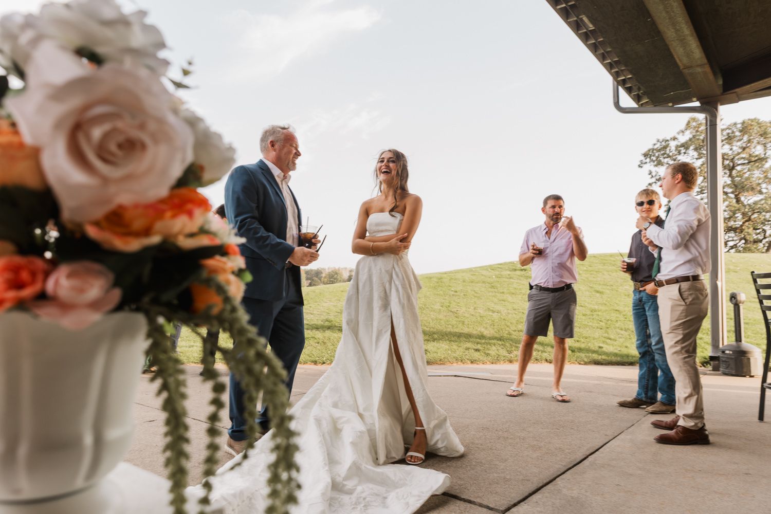 Wedding reception setup with floral centerpieces and outdoor pavilion seating.