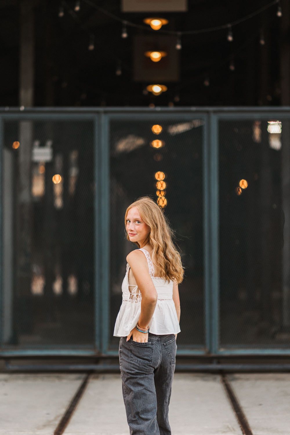 A fashion portrait session against an urban background with soft lighting and glass windows.